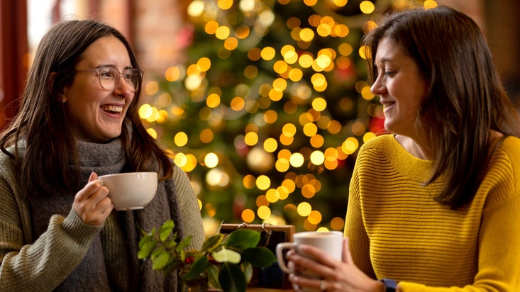 Visits chatting in the cafe over a cuppa with a Christmas tree in the background